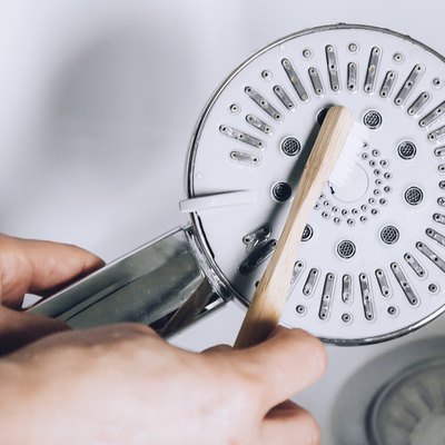cleaning showerhead with toothbrush
