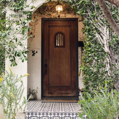 Exterior entryway with painted tile steps and wooden exterior door