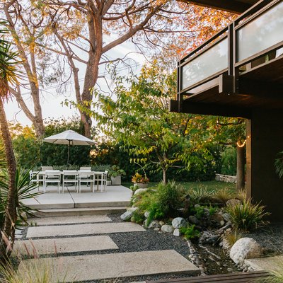 outdoor idea with tropical patio design featuring limestone path and white patio furniture