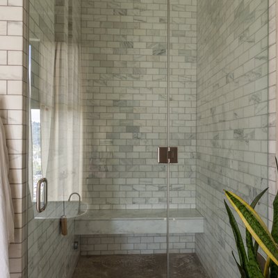 shower with light subway tile  wall and bench