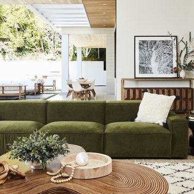 boho green room with luxe velvet sofa and wood coffee table