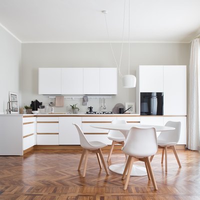 white kitchens with wood floors with scandinavian table and white chairs