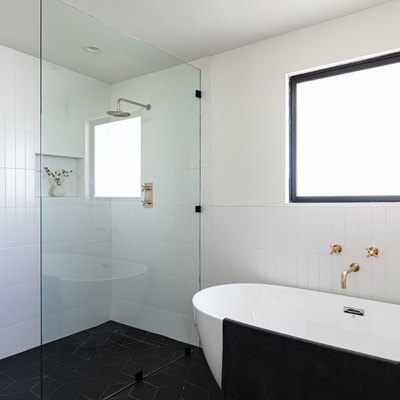 bathroom with shower with glass wall, and stand-alone bathtub