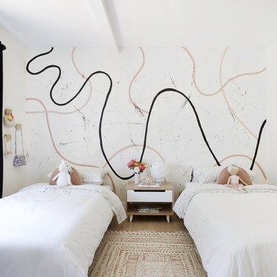 Kids' minimalist bedroom with modern mural and white bedding