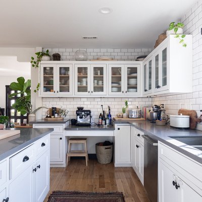 kitchen with glass-insert cabinets above and white cabinets with dark pulls below