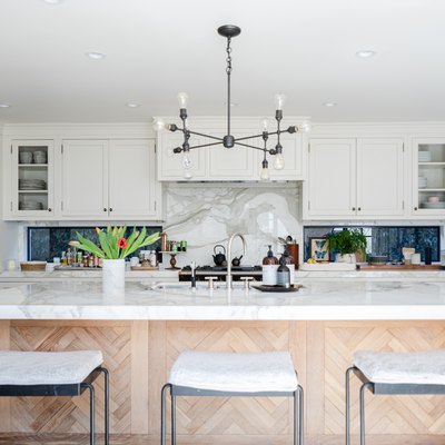 kitchen island with white stone countertop and modern pendant light