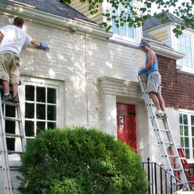 Men painting a brick house