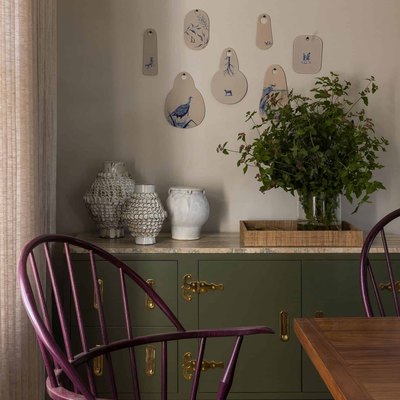 Taupe color in dining room with purple chairs and green buffet