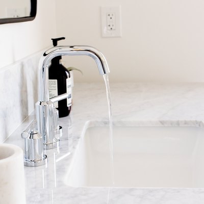 undermount sink with silver faucet, quartz countertop, white toothbrush holder