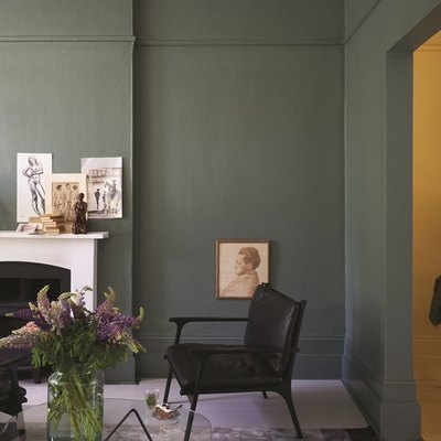 living room with dark green walls and white fireplace