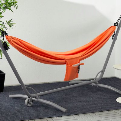 orange hammock under umbrella near small white table