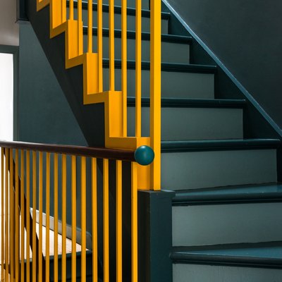 painted stairs with yellow handrail teal steps