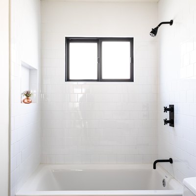bathroom with shower/tub combo and black accents