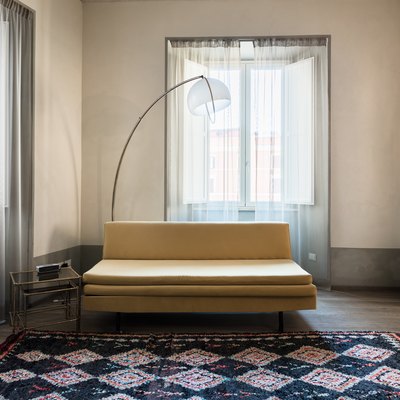 Tan couch with colorful geometric rug