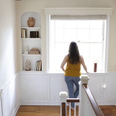 Woman looking out of a bay window