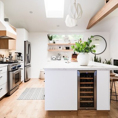 kitchen window in modern kitchen with skylight, exposed wood ceiling beams, and white island