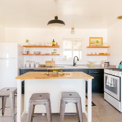 open kitchen with wood countertop island, exposed shelving