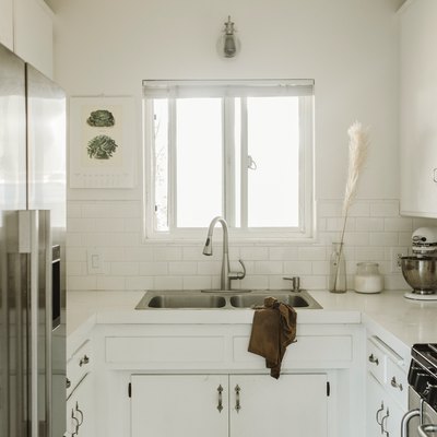 small white kitchen with stainless steel fridge and double bowl sink