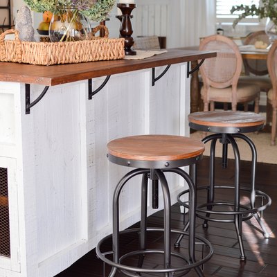 Industrial farmhouse kitchen with white island and metal bar stools