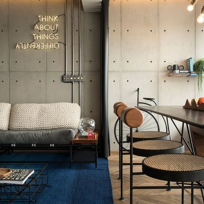 industrial style apartment with neon sign hanging on wall and unique chandelier