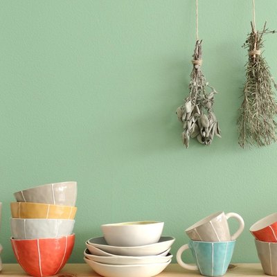 dishes and mugs with green wall in backround