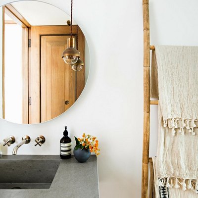 small bathroom lighting idea with mini pendant at vanity near round mirror on the wall and concrete sink