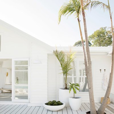 White exterior beach house colors with deck and palm trees