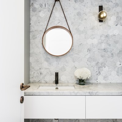 wall sconce bathroom light fixture with hexagonal wall tile and marble countertop