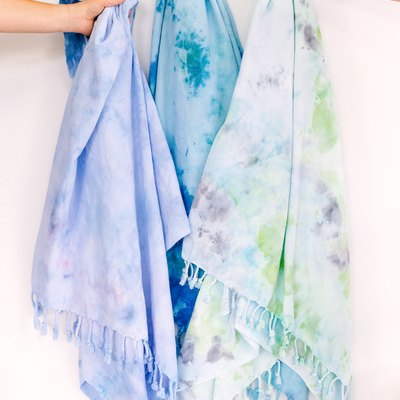Hands holding ice-dyed towels.