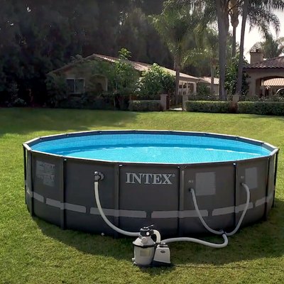 intex above-ground pool in backyard with two lawn chairs and a side table
