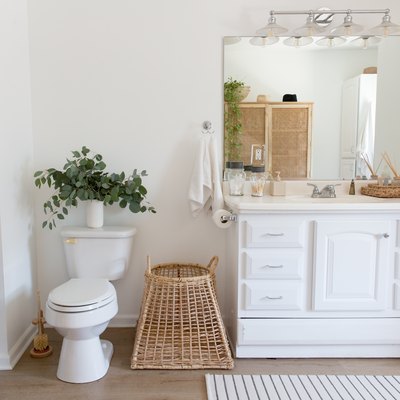 view of single-sink bathroom vanity, bathroom mirror, toilet and decorative baskets