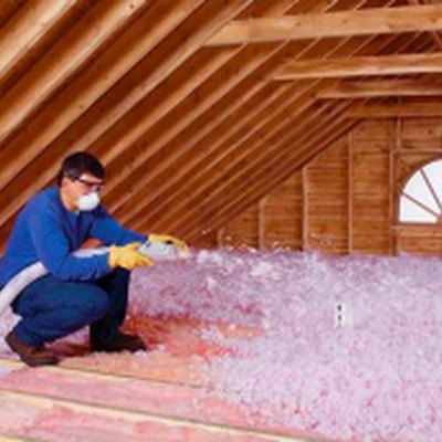 Blowing attic insulation.