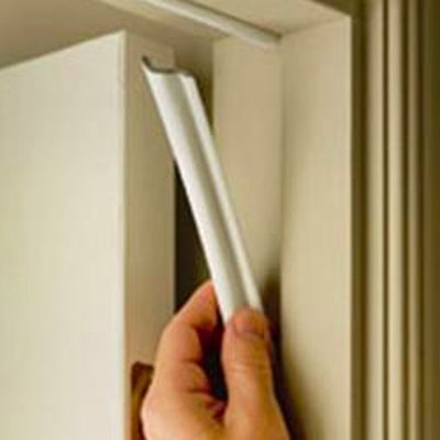 Installing weather stripping on door frame.