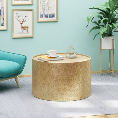 gold round coffee table with light blue background