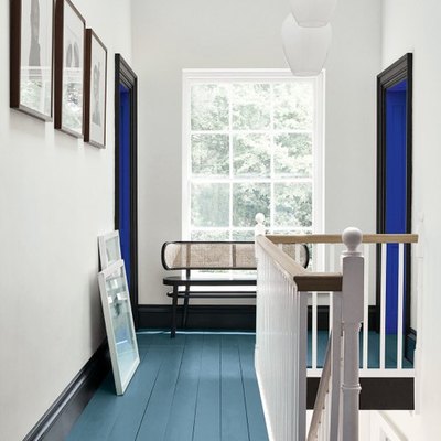 white hallway with green floors and black doorways