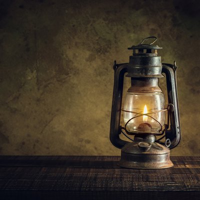 kerosene lamp oil lantern burning with glow soft light on aged wood floor