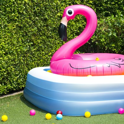 Inflatable pool with flamingo balloon in garden