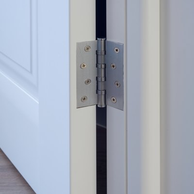 Metal chrome hinged hinges on a white interior door
