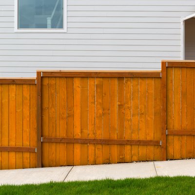 New home backyard red stained cedar wood fence construction