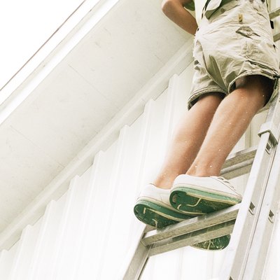 Man standing on ladder, low angle view