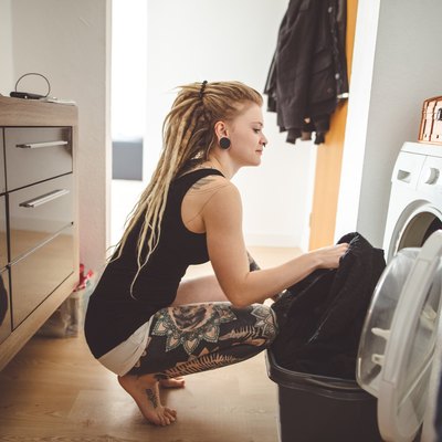 Young woman doing laundry at home.