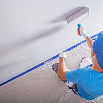 High Angle View Of Worker Painting On Wall At Home