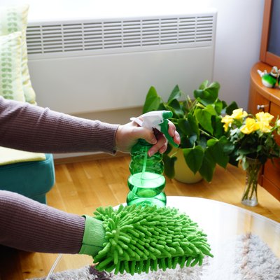 Home cleaning products, sponge and detergent in women hands that clean the glass table
