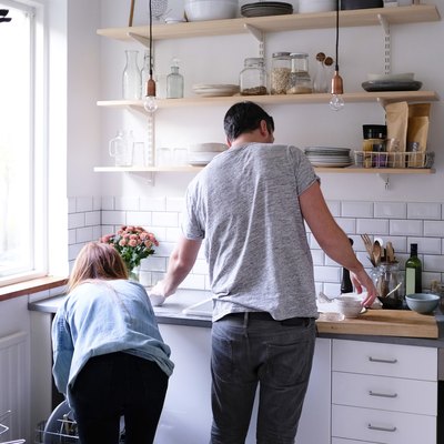 Rear view of couple working in kitchen at home