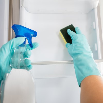 Close-up Of Person Hand Cleaning Refrigerator