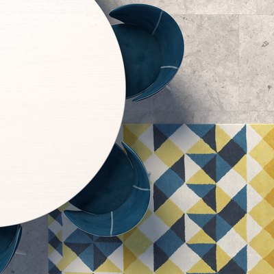 Empty white tabletop with blue armchair standing on the concrete floor with geometric patterned carpet