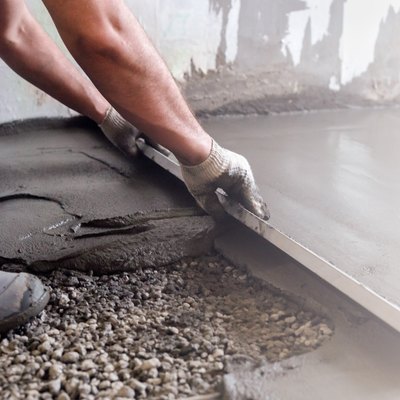 Worker levels a floor cement mortar. Equal floor. Repair of the house.