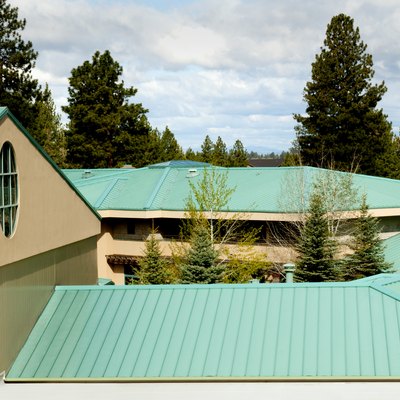 A green steel roof amongst trees