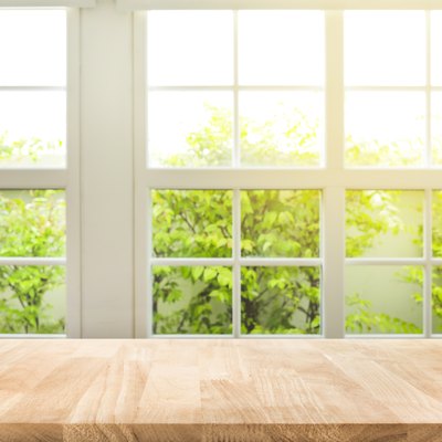 Top of wood table counter on blur window view garden background.