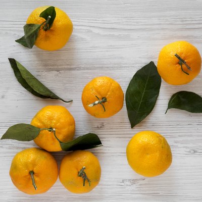 Fresh ripe tangerines on a white wooden surface, top view. Flat lay, from above, overhead.